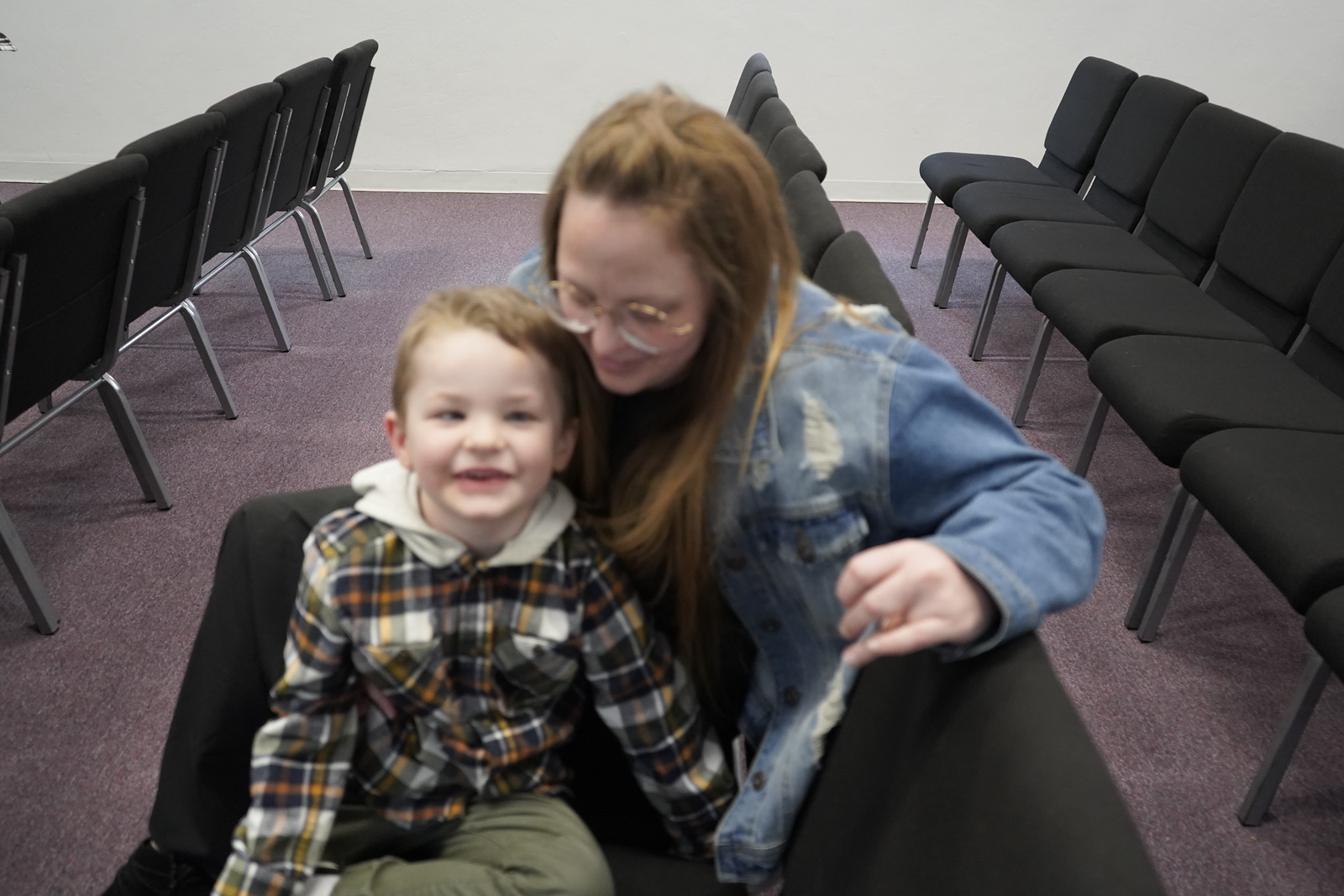 A smiling young child with a caring adult at Refuge Church